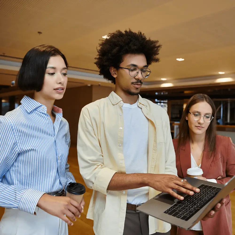 Young people working with laptops on AI projects during a Teens in AI programme
